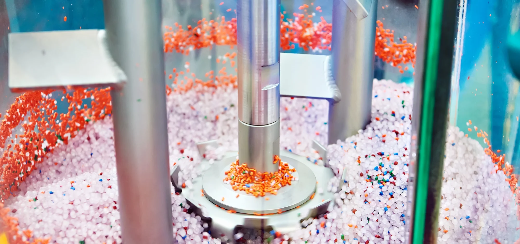 Thermoplastic resin pellets being mixed inside a drying system, illustrating material preparation and moisture‑removal processes for efficient thermoplastic engineering.
